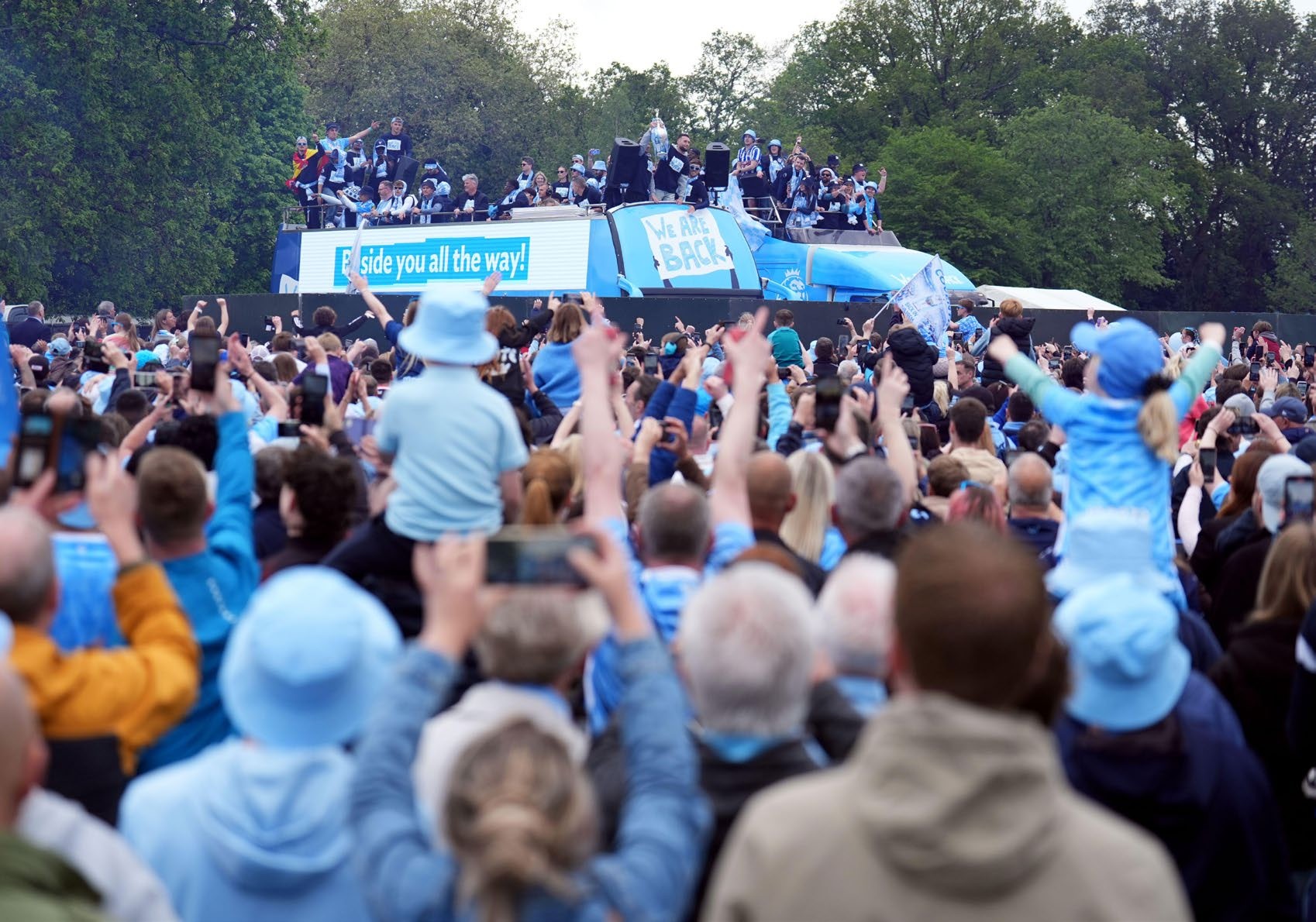 Coventry fans swarm around the open top bus during the parade.