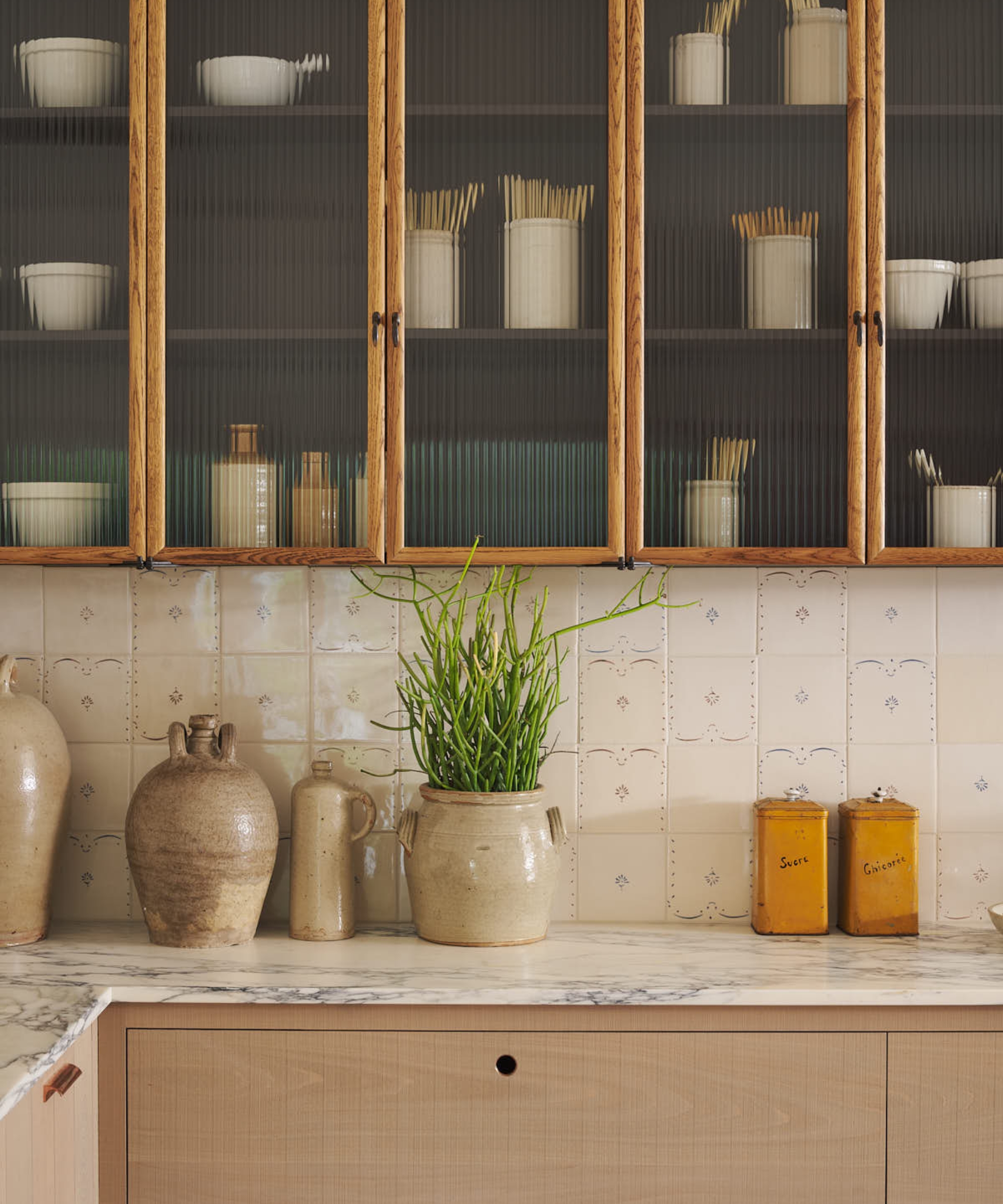 A delft tiled splashback in a wooden kitchen