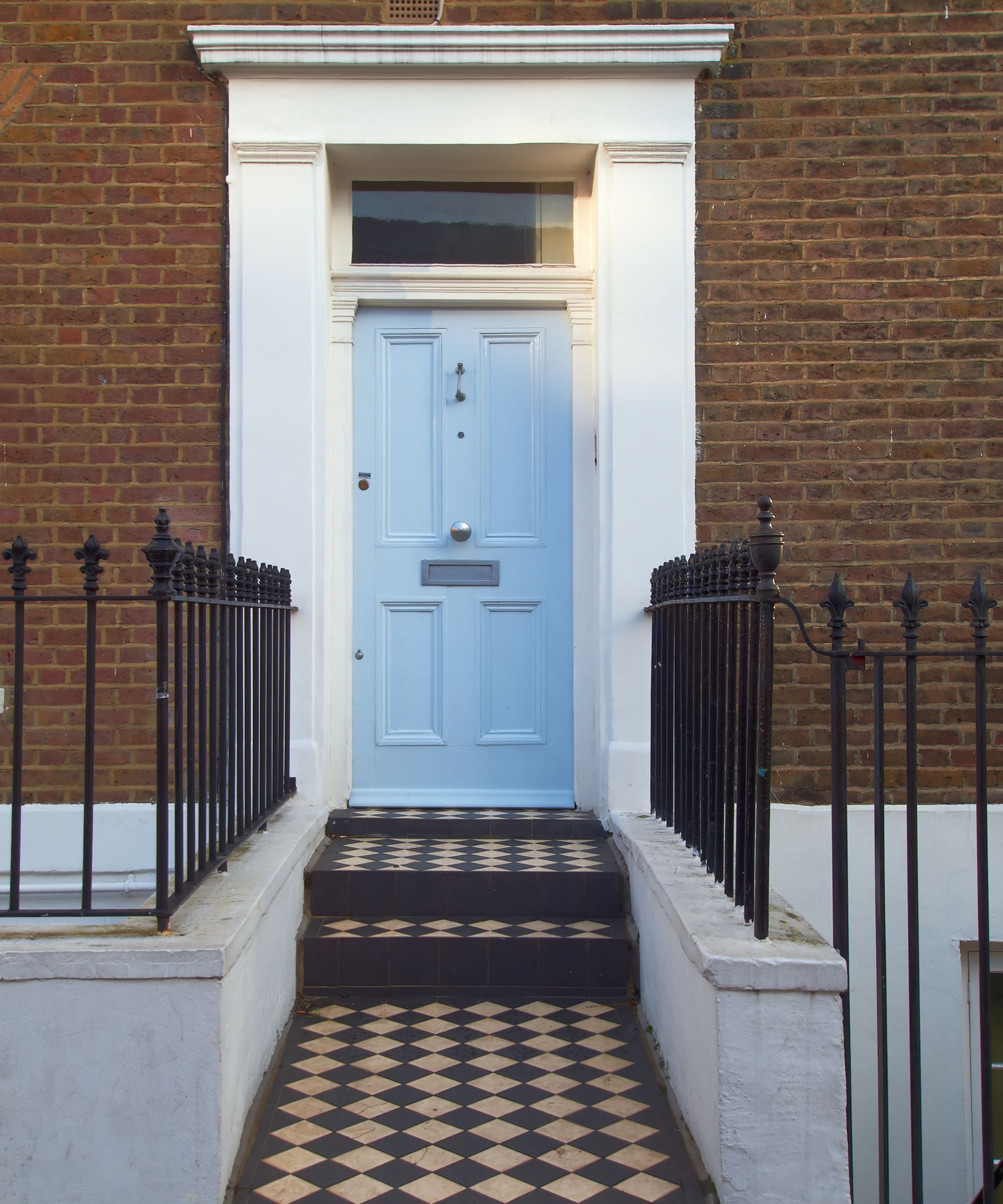 A red brick house with a baby blue front door