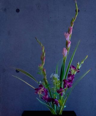 A Ikeaba flower arrangement with purple flowers