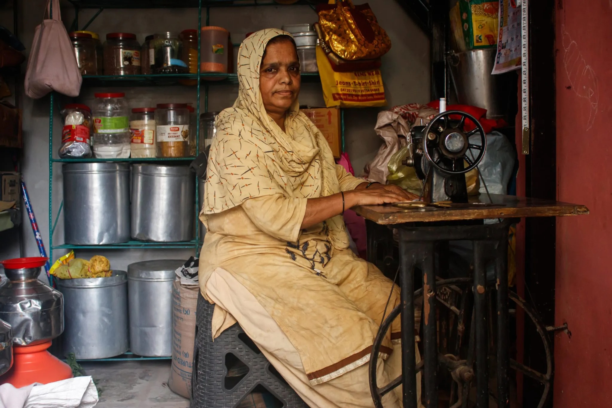 A photo of an Indian woman working at a sewing machine