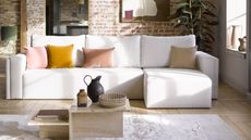 exposed brick wall with large white sofa cushions and soft rug - sofa.com