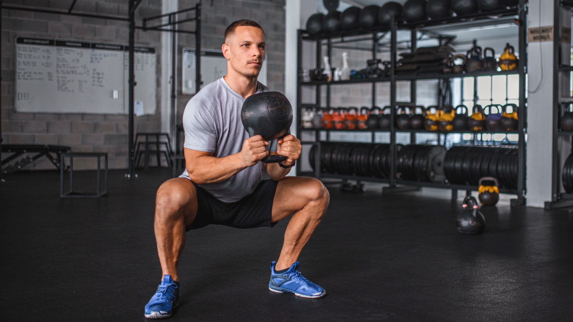 A man performing a kettlebell squat