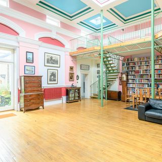 hall with wooden flooring and bookshelves