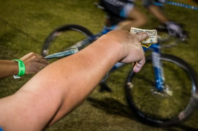 Fans try to hand up money to passing riders.