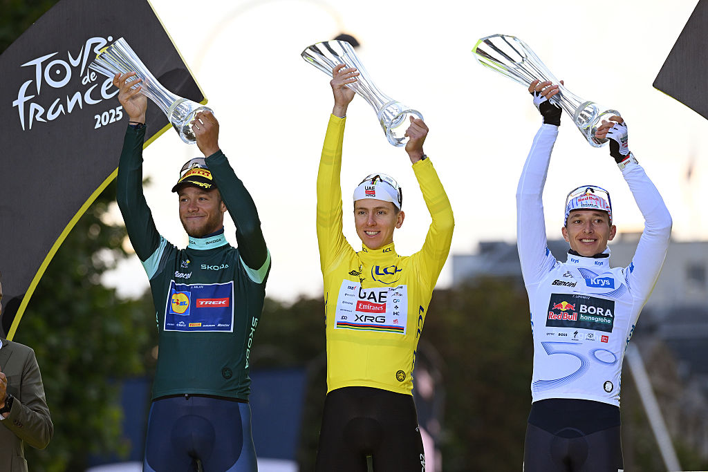 PARIS - CHAMPS-ELYSEES, FRANCE - JULY 27: (L-R) Jonathan Milan of Italy and Team Lidl - Trek - Green Sprint Jersey, Tadej Pogacar of Slovenia and UAE Team Emirates - XRG - Yellow leader jersey / Polka dot Mountain Jersey and Florian Lipowitz of Germany and Team Red Bull - BORA - hansgrohe - White best young jersey celebrate at podium during the 112th Tour de France 2025, Stage 21 a 132.3km stage from Mantes-la-Ville to Paris - Champs-Elysees / #UCIWT / on July 27, 2025 in Paris - Champs-Elysees, France.