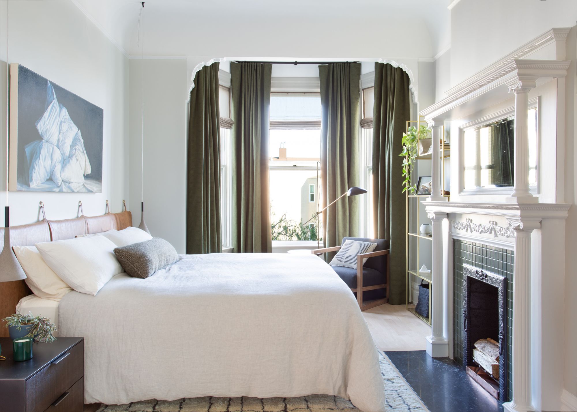 white bedroom with bay window and dark green curtains