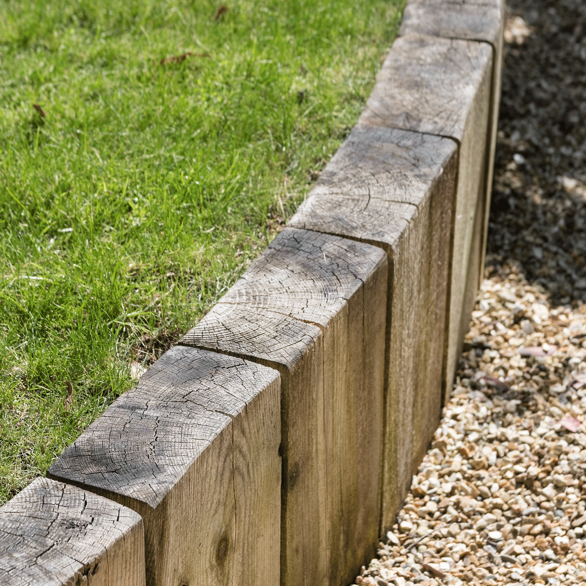 a garden with a raised lawn with railway sleepers used as the edging