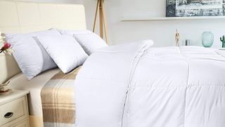 Utopia Bedding Comforter Duvet Insert shown in a white bedroom next to cream bedside table