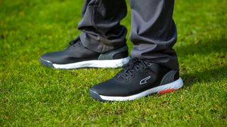 Puma Alphacat Nitro Golf Shoes worn on the golf course in a black and white colorway
