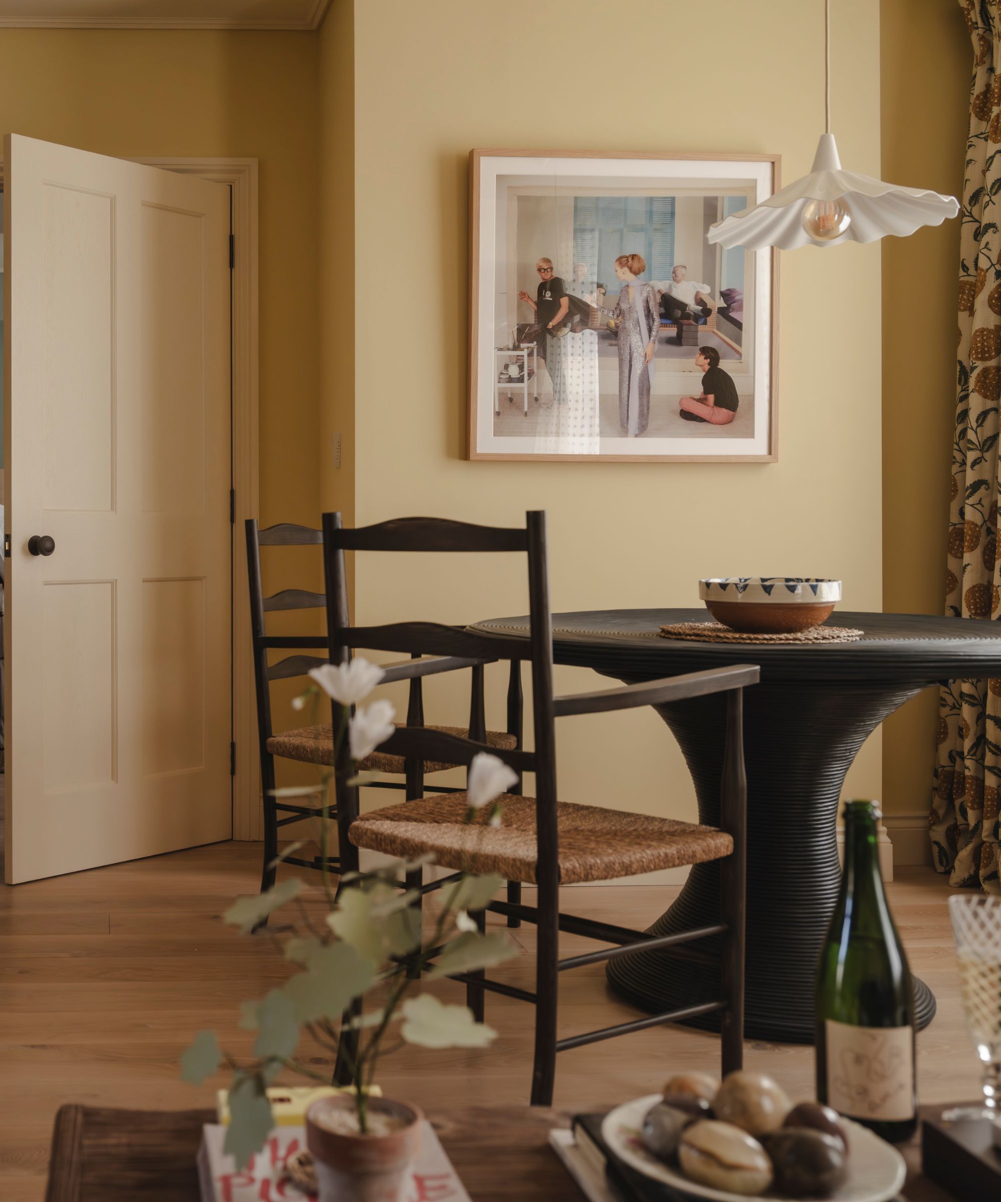 a butter yellow small cotswolds apartment with a breakfast dining nook and cecil beaton print