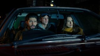 Three people look out of the front window of a car, in 'Black Doves.'