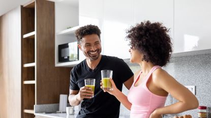 Two people drinking post-workout smoothies at home