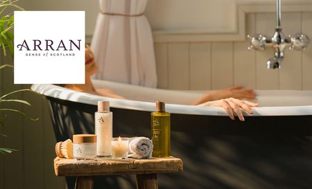 Woman in bathtub using Arran bath and skincare products