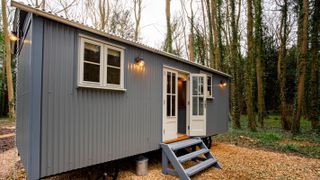 grey shepherd's hut in garden