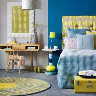 blue walled bedroom with carpet flooring and yellow textured bed