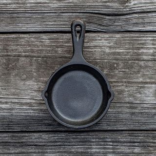 A black mini cast iron skillet with a wood background 