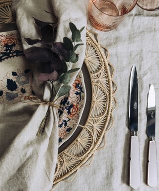 Thanksgiving table decor ideas with a simple grey linen tablecloth, woven placemat and floral plate
