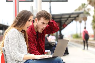 A couple looks surprised as they look for information online.