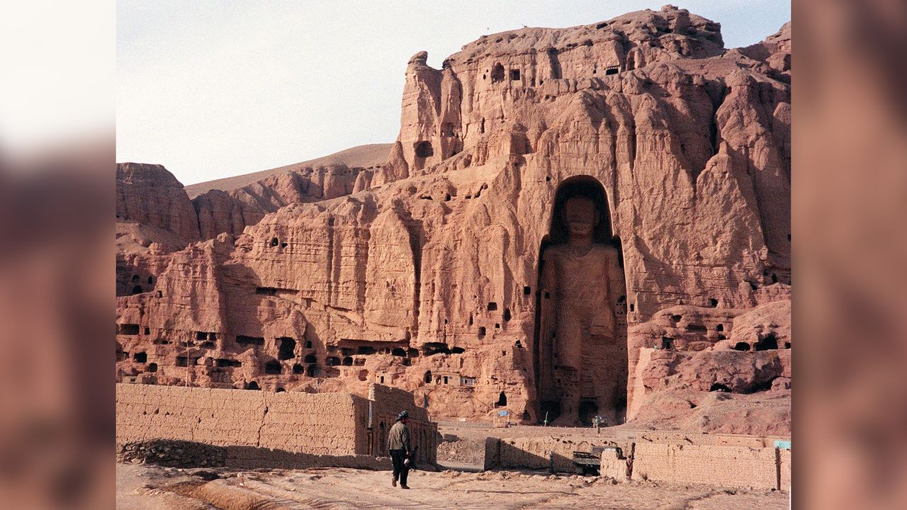 An Afghan walks near the world&rsquo;s tallest standing statue of Buddha in Bamiyan province in Afghanistan on Dec. 7, 1997, years before the statue was destroyed by the Taliban in 2002.