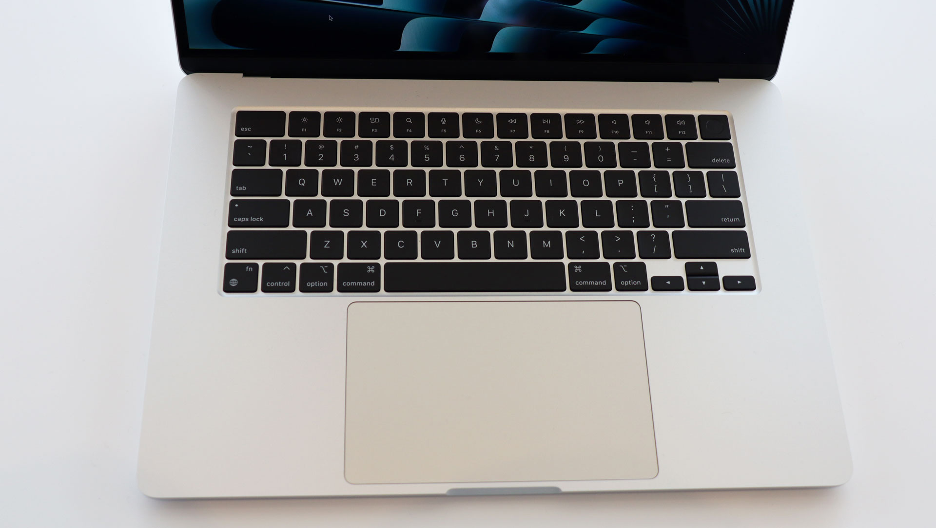 En åpen 15-tommers MacBook Air på et lyst bord.