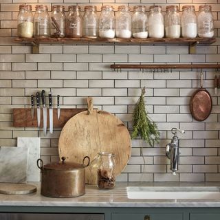 White kitchen tiles with jars on floating shelf