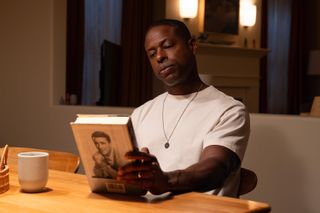 sterling k brown as xavier looking at a book at a kitchen table in a still from the paradise season 1 finale