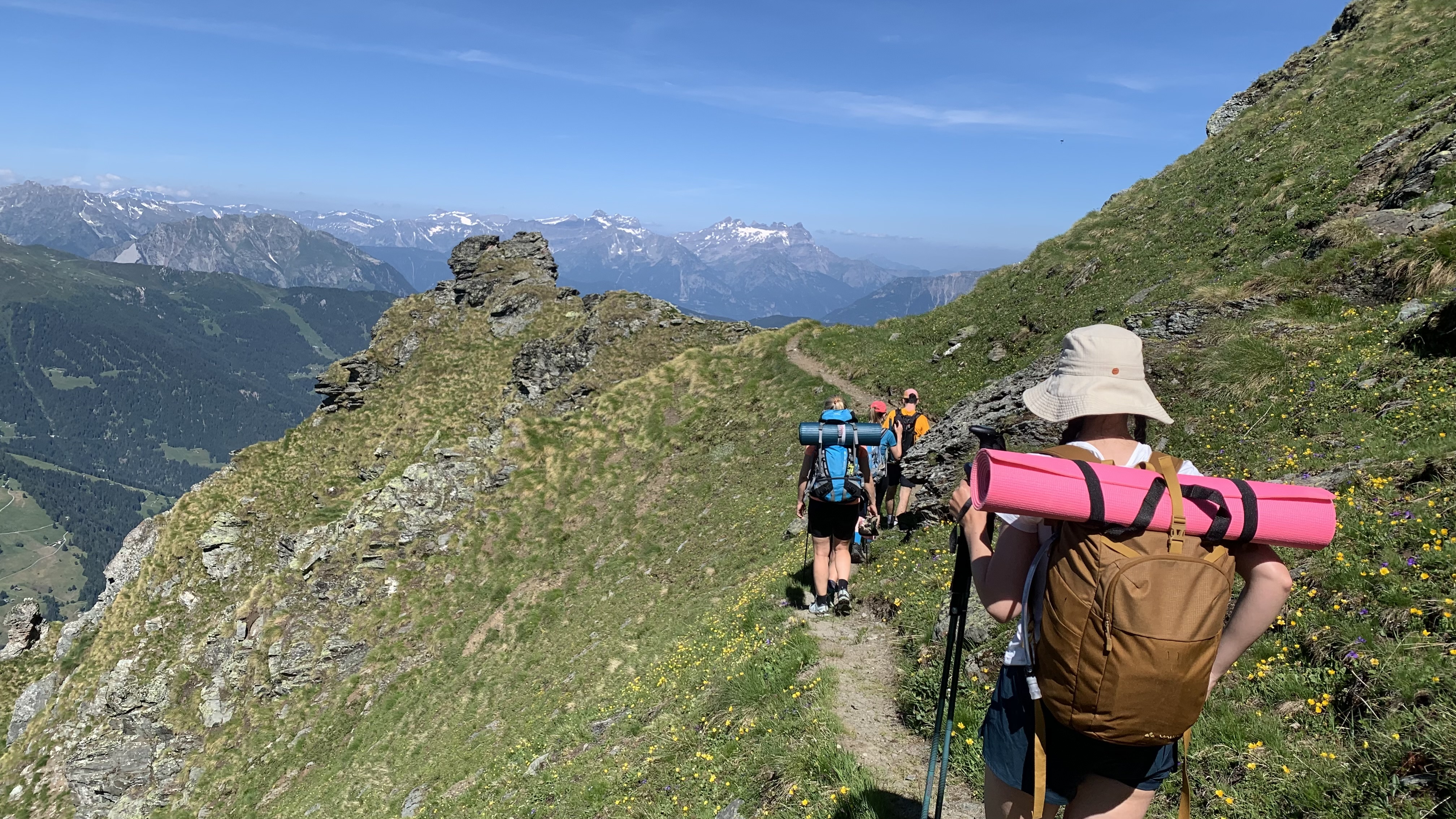 Women hiking to Cabane de Louvie with yoga mats on their backpacks