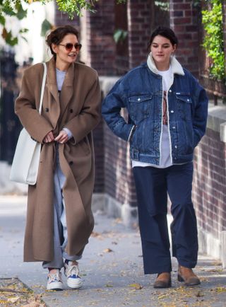 Katie Holmes and Suri Cruise walk in Manhattan where Katie wears a camel coat and Suri wears a denim trucker jacket