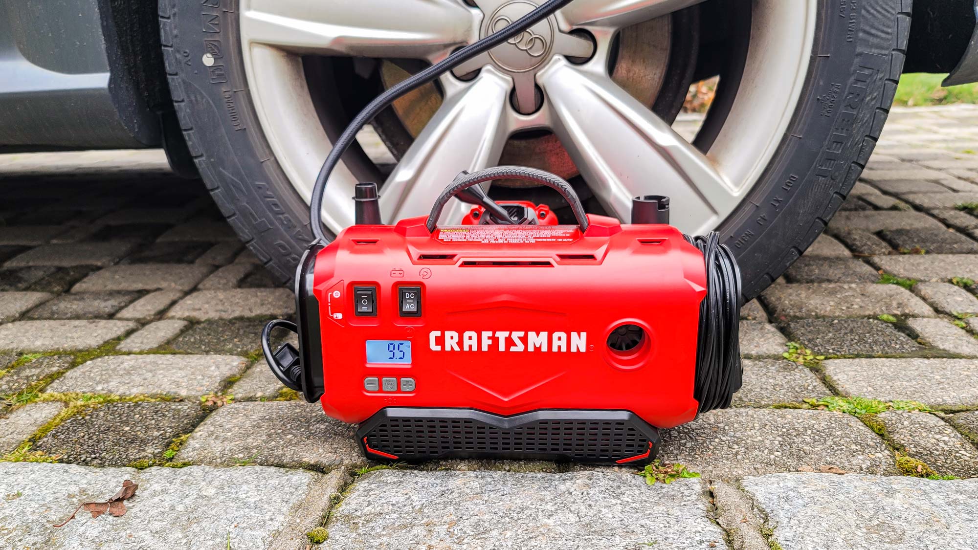 Craftsman V20 Inflador de neumáticos inalámbrico junto al neumático del automóvil