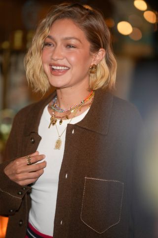 gigi hadid wearing several charm necklaces