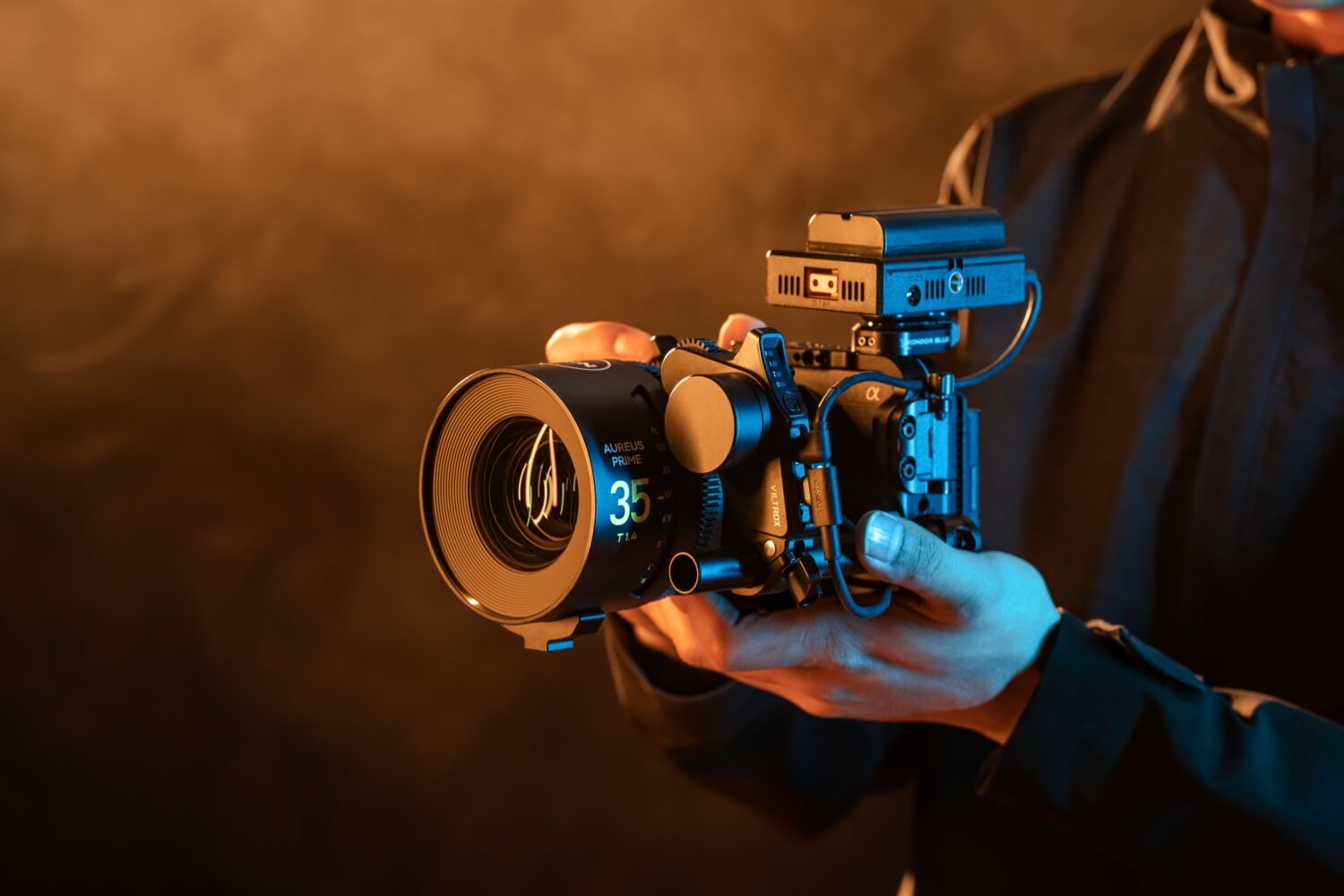 A camera and cine lens being used in hand
