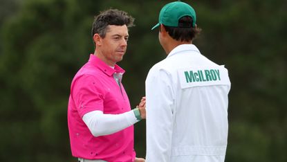 Rory McIlroy shakes hands with his caddie