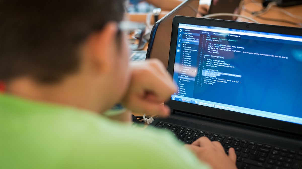 A person coding on a laptop computer