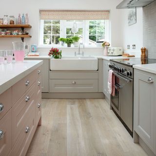 kitchen room with wooden flooring and cabinets with white sink