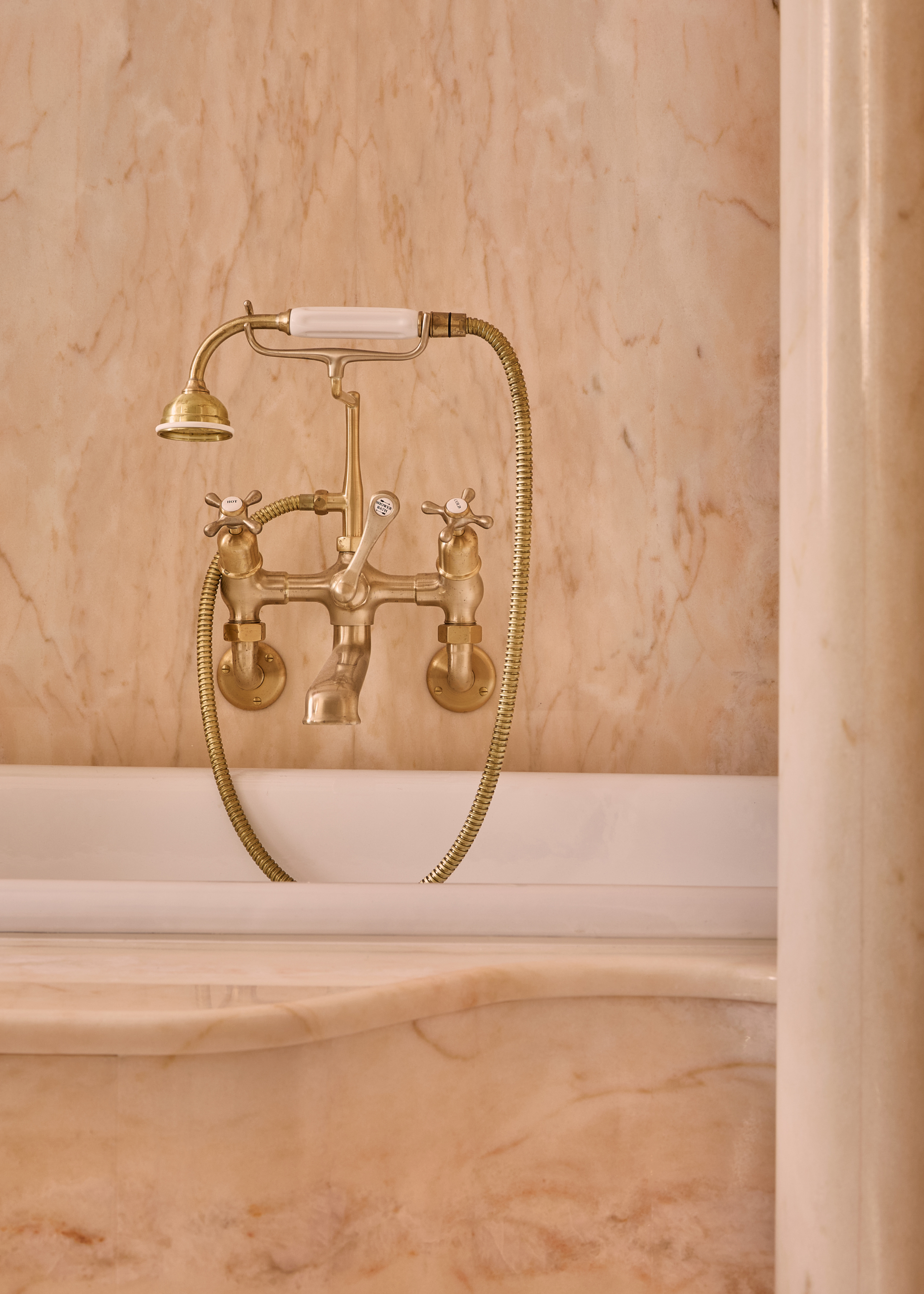 close up of a pink bath with brass taps