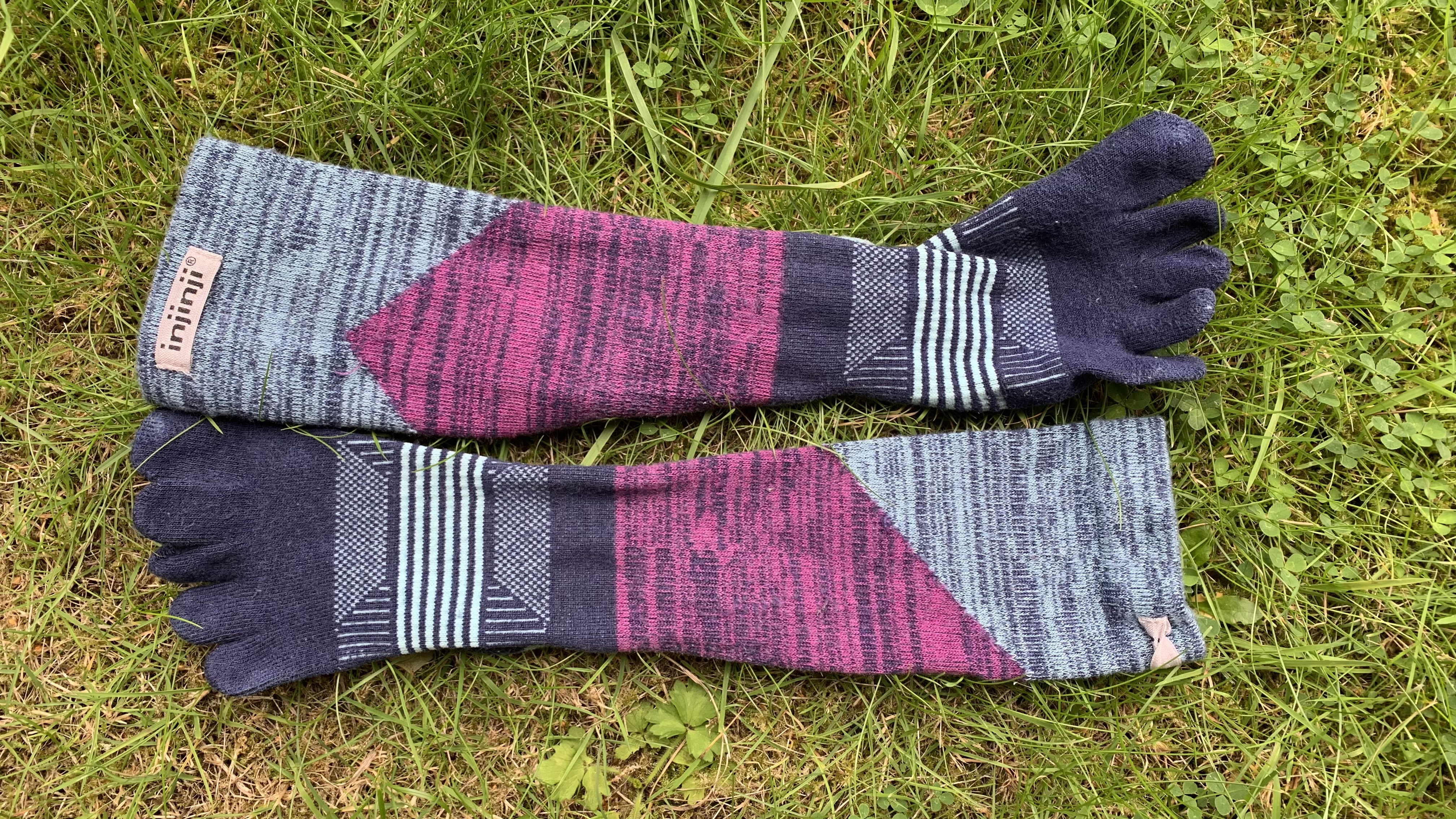 Injinji Trail Midweight Crew toe socks laid out on the grass