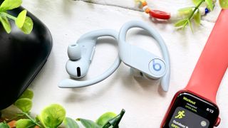 Hero image for the best Beats headphones showing the Beats Powerbeats Pro sitting next to an Apple Watch