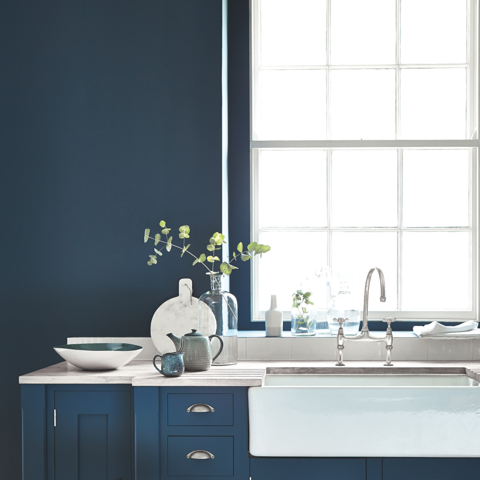 a kitchen painted in little greene hicks blue with white butlers sink