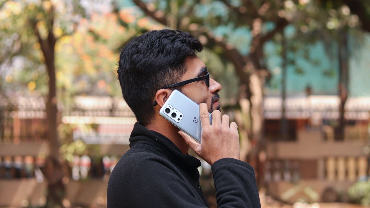 A OnePlus 9 Pro from the back, being used to make a call