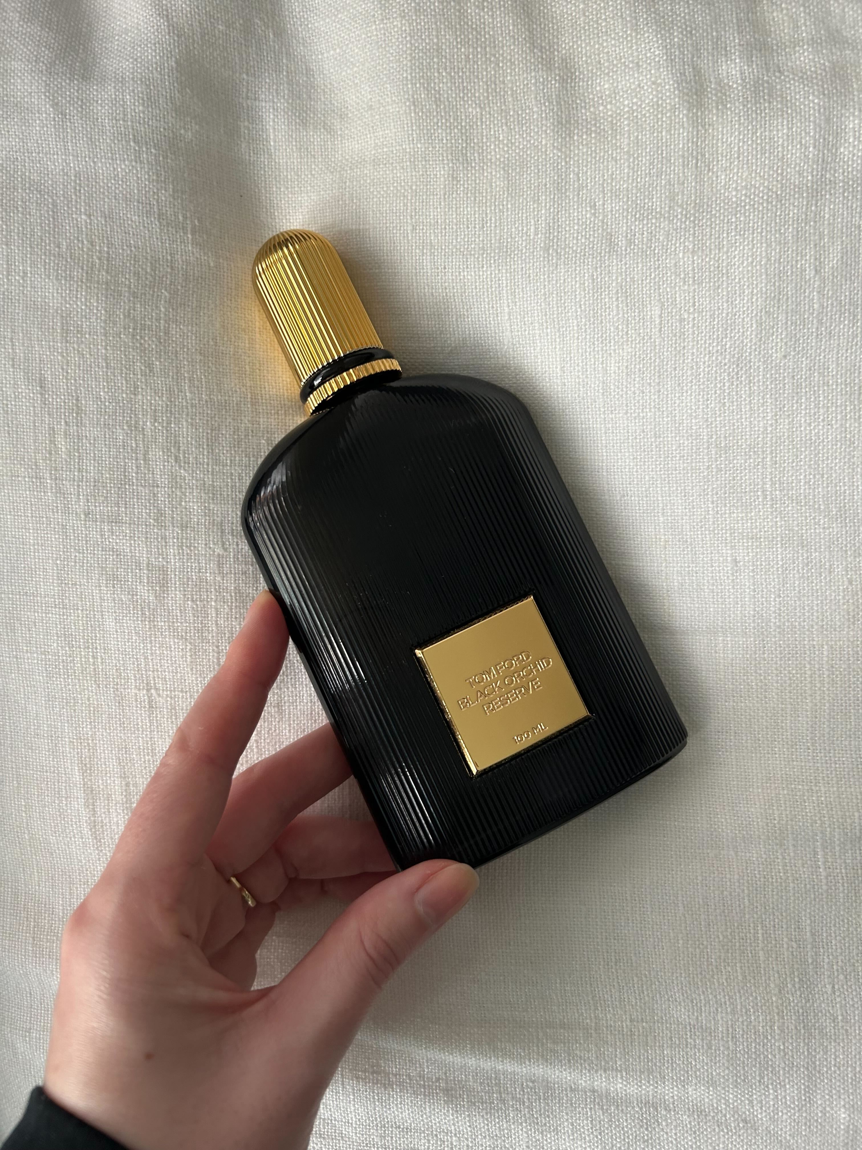 Junior beauty editor Grace Lindsay holding a bottle of Tom Ford Black Orchid Reserve