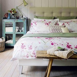 bedroom with wooden flooring and floral printed bedding set on bed