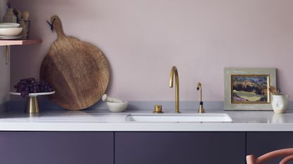 Lavender painted kitchen with golden tap and chopping board