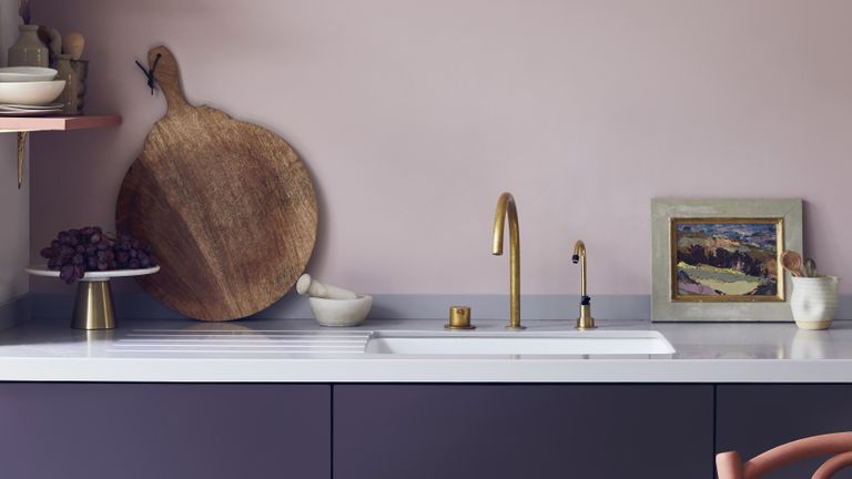 淡紫色的厨房，金色的水龙头和砧板