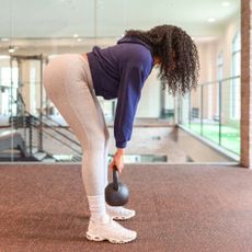 A woman doing deadlifts at the gym