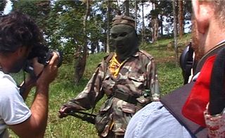 Masked man holding a gun outdoors