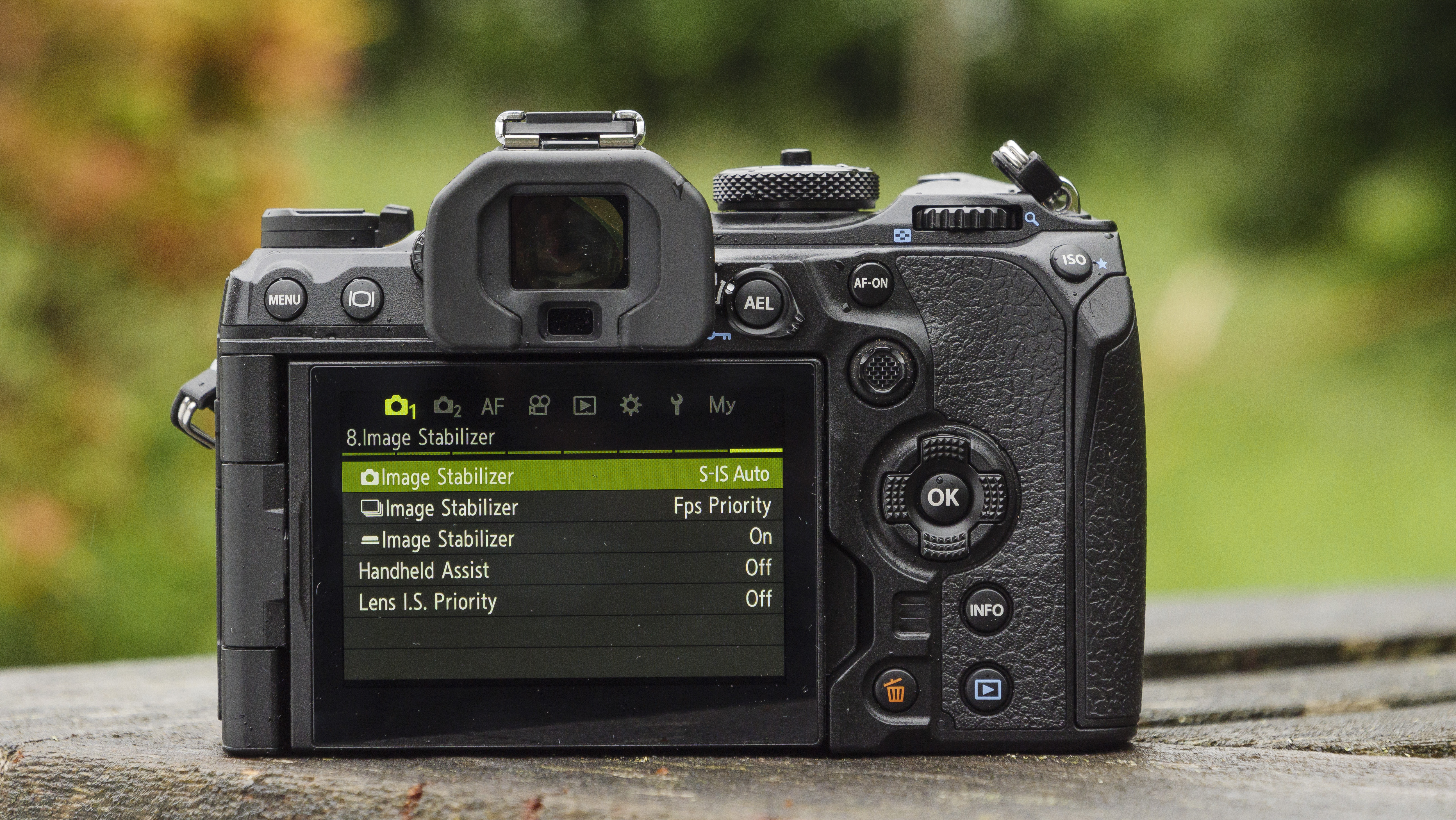 The rear screen of the OM System OM-1 camera sat on a wooden table