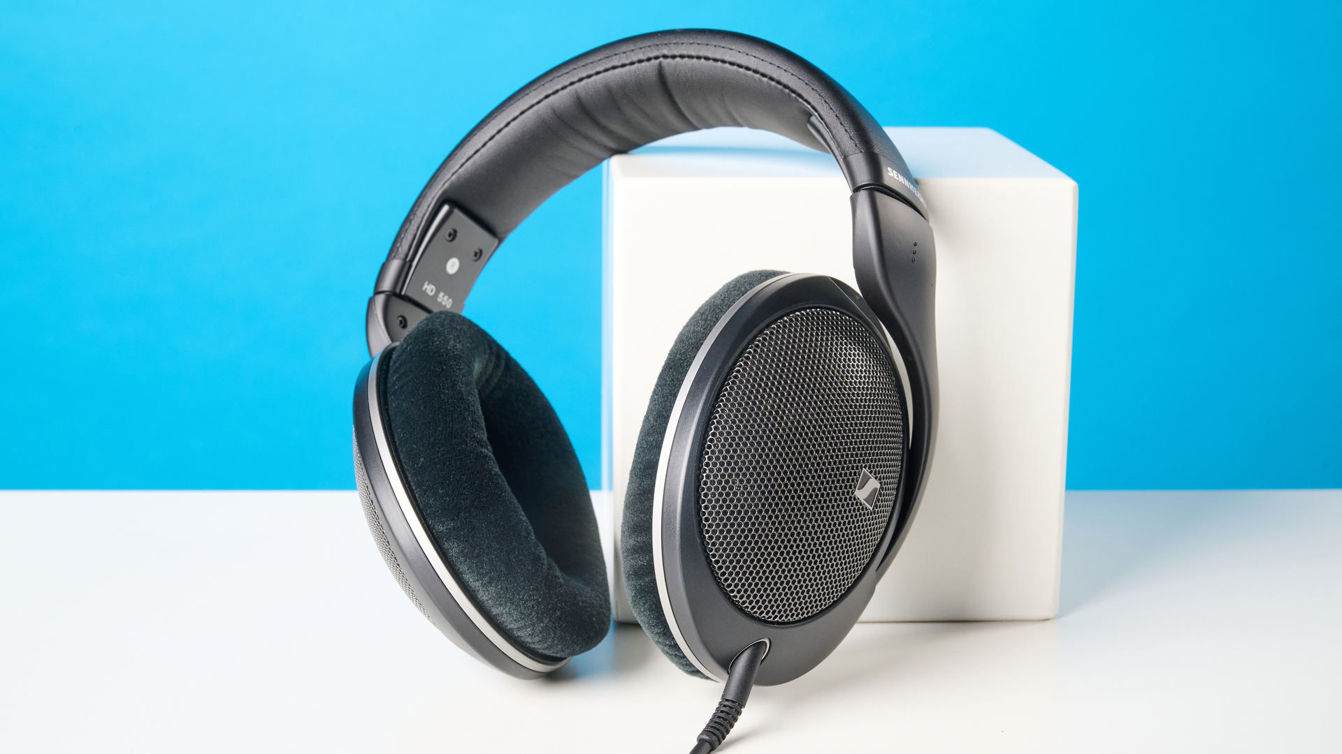 The Sennheiser HD 550 headphones on a stone surface with a blue background