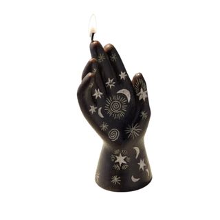 A black hand candle with star symbols on it