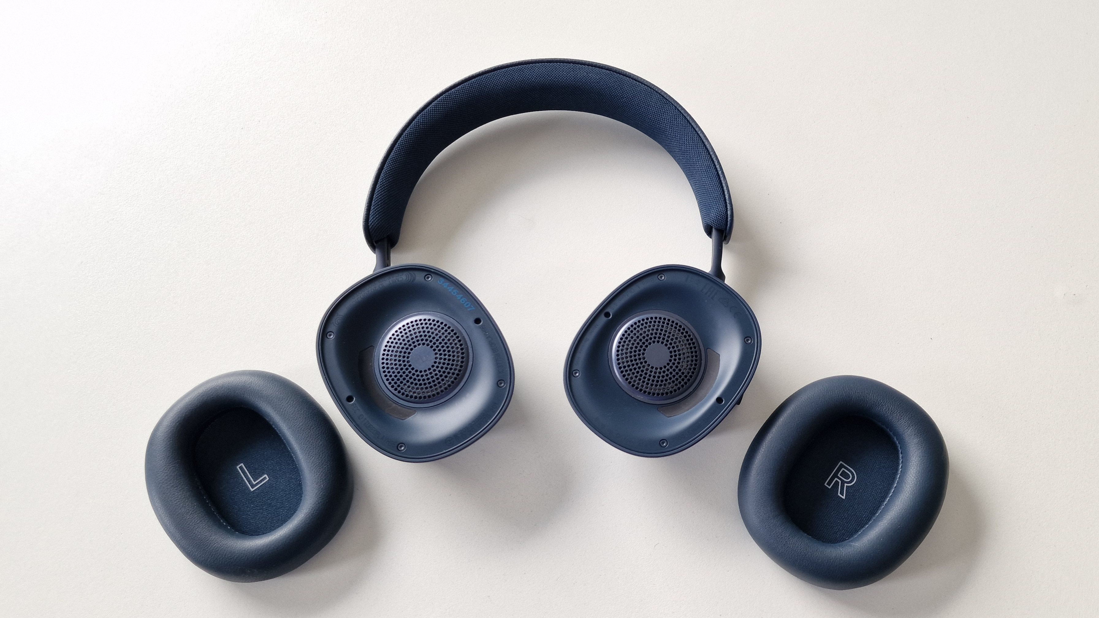 Beoplay H95 med ørepuderne afmonteret og liggende ved siden af